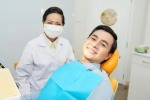 smiling-ethnic-dentist-and-man-in-dental-chair-CNVS7GE (1)
