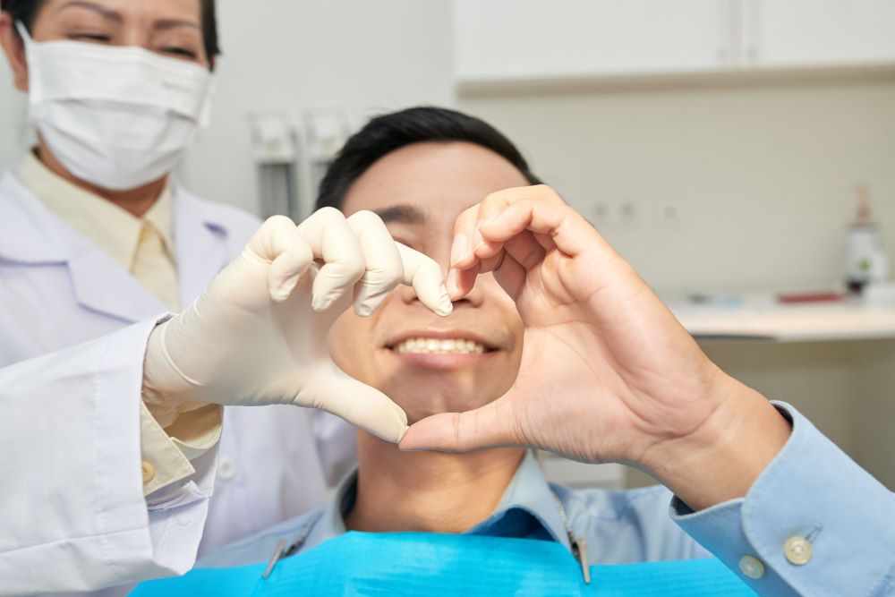 patient and dentist showing heart gesture with han 2G5ZQAF
