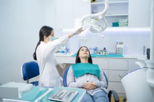 asian female dentist adjust dental surgical light 2021 12 09 07 32 46 utc 1