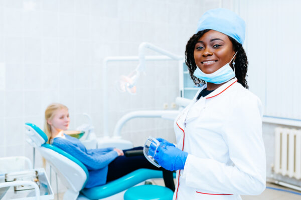 African american female dentist treating patient at clinic