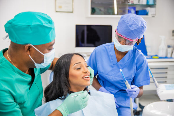 An African woman during a dental visit receives a dental cleaning