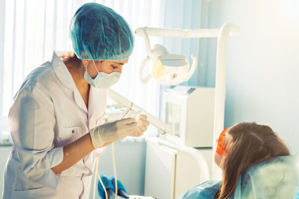 A young female dentist and a patient.