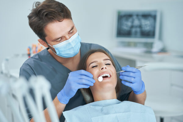 Male dentist and woman in dental clinic