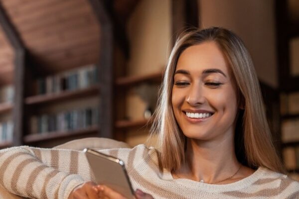 portrait-of-smiling-woman-using-cellphone-at-home-2022-12-16-08-01-27-utc (1)