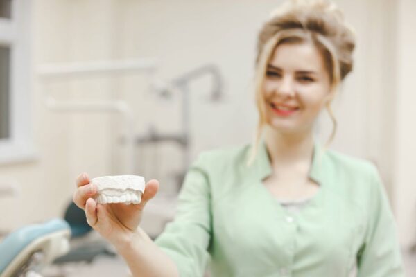 woman-doctor-orthodontist-shows-a-plaster-cast-of--P5AF6LN